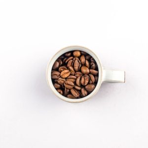 Boabe de cafea in cana alba