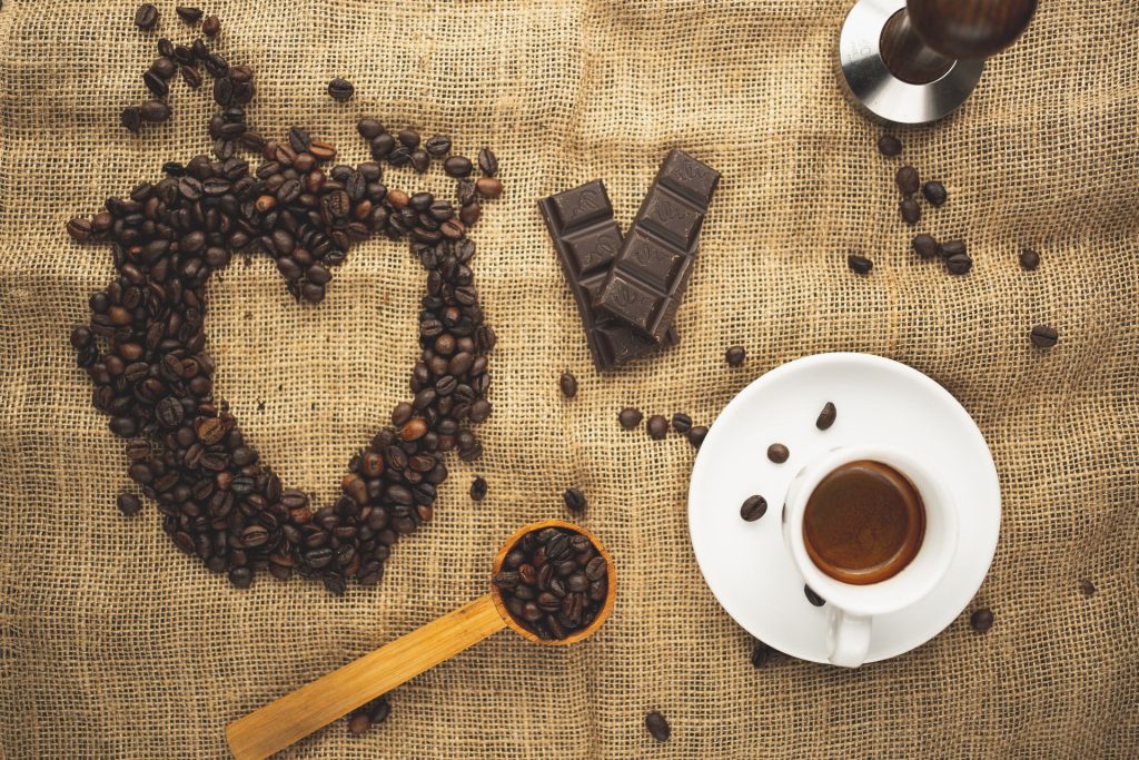 Boabe de cafea prajite si espresso pe fundal rustic